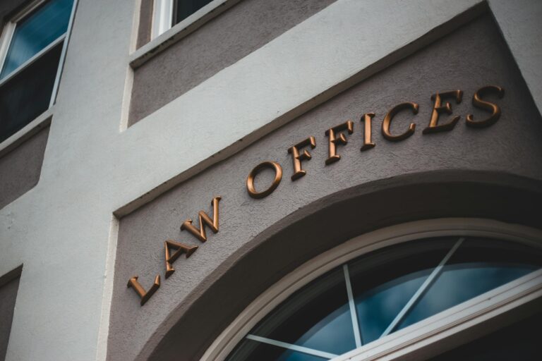 Low angle view of a modern law office exterior with elegant facade and arched entrance.